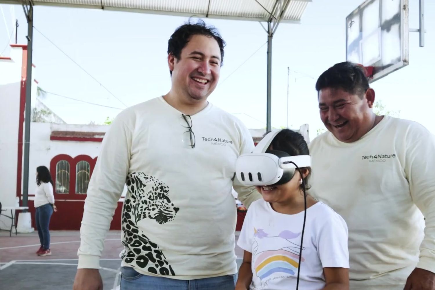A girl tries on virtual reality goggles alongside community monitors